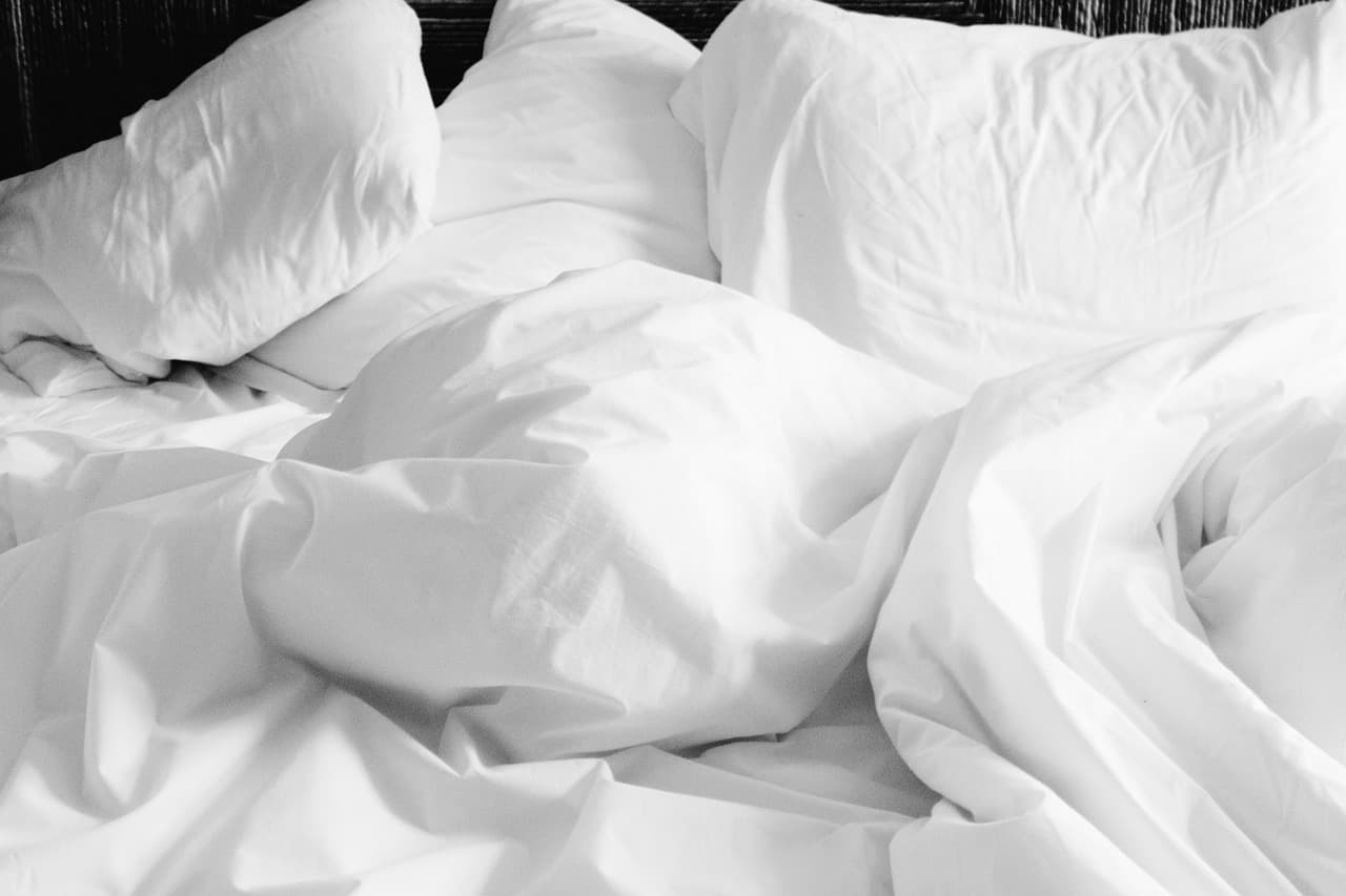Sanftes Morgenlicht auf zerknittertem Leinen, zwei Hände im weichen Schatten
