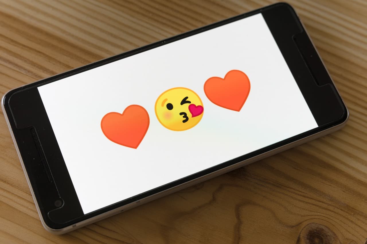 Leuchtender Smartphone-Bildschirm mit Herzsymbolen und getipptem Text