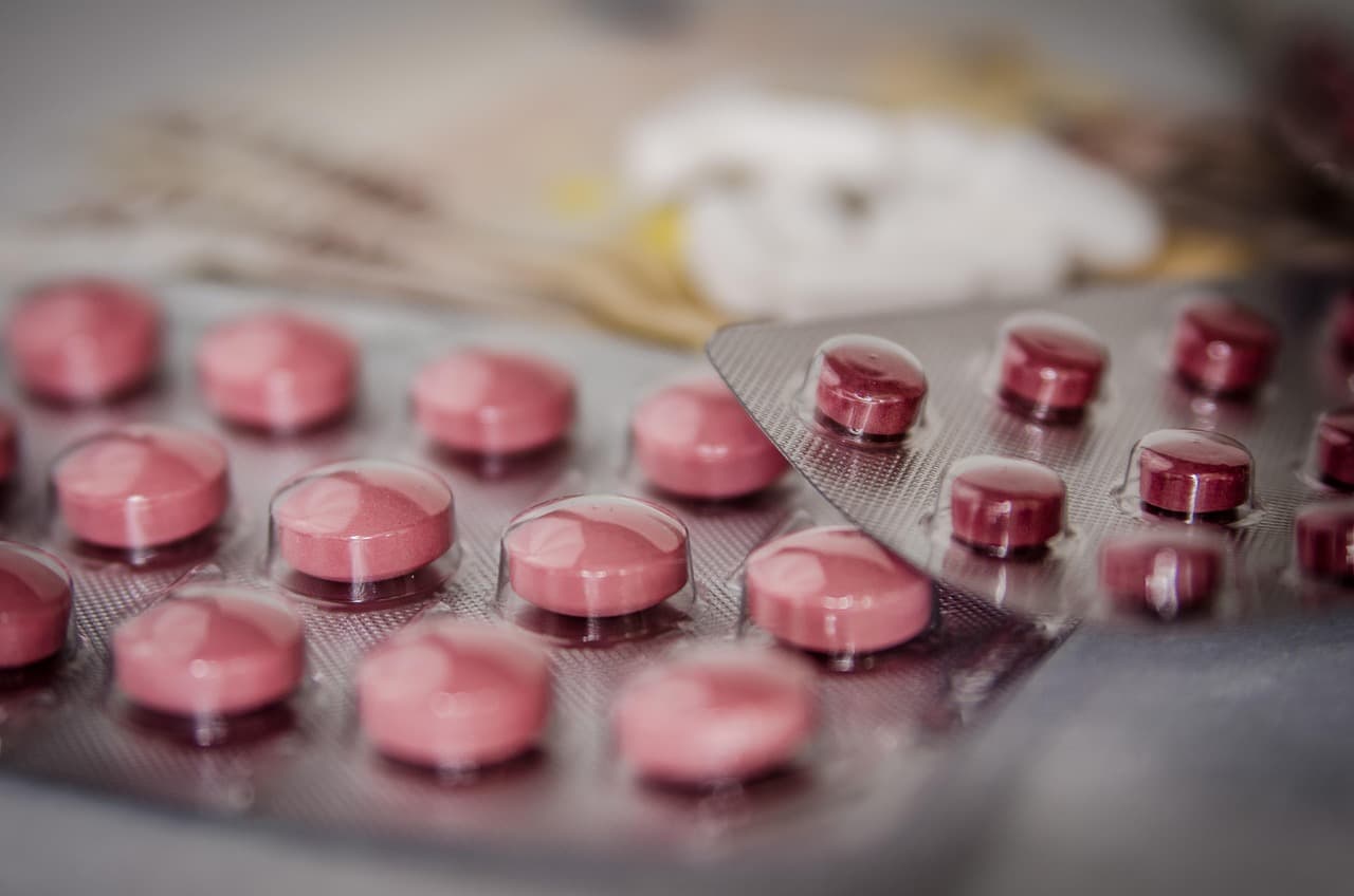 Nahaufnahme rosafarbener Tabletten in zwei angebrochenen Blisterpackungen