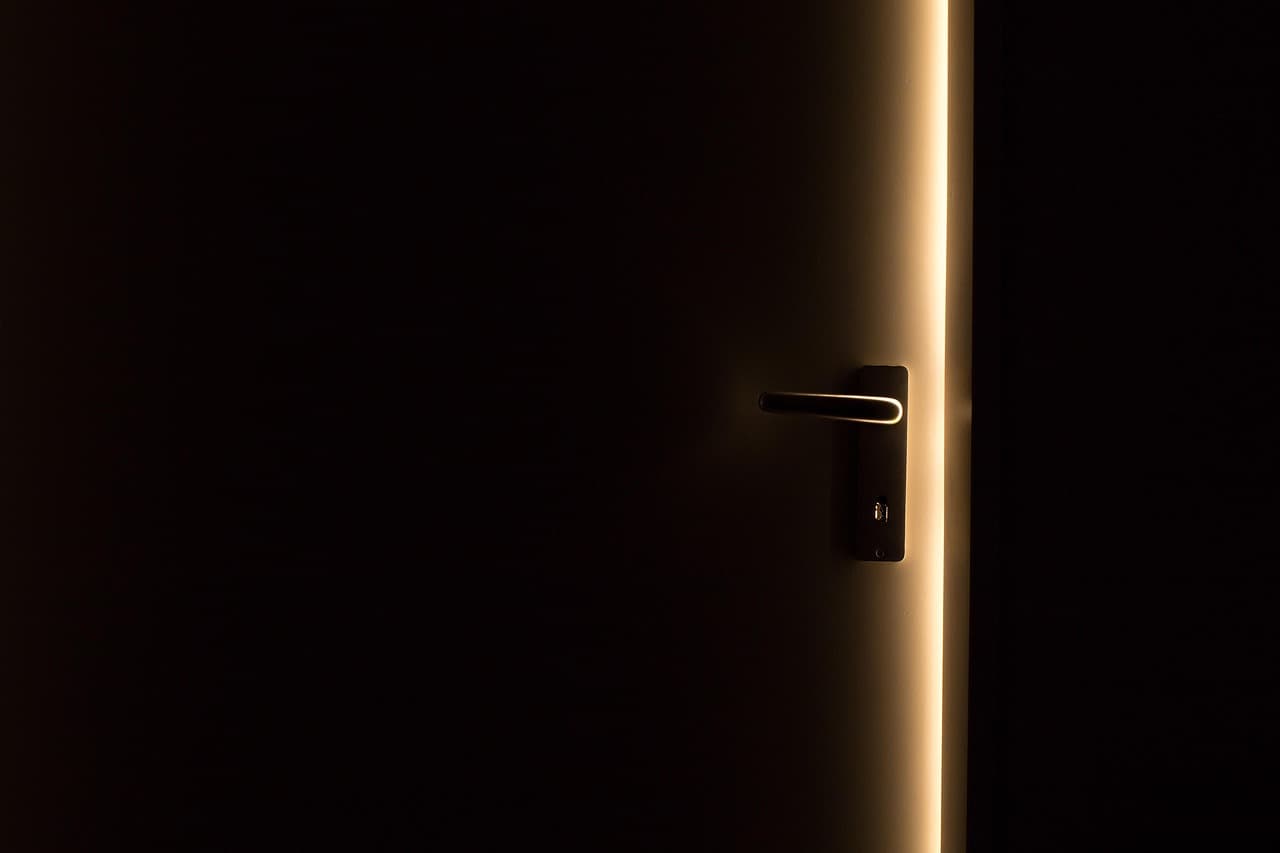 Halb geöffnete Küchentür im Abendlicht, ein Hemd lässig über einem Stuhl
