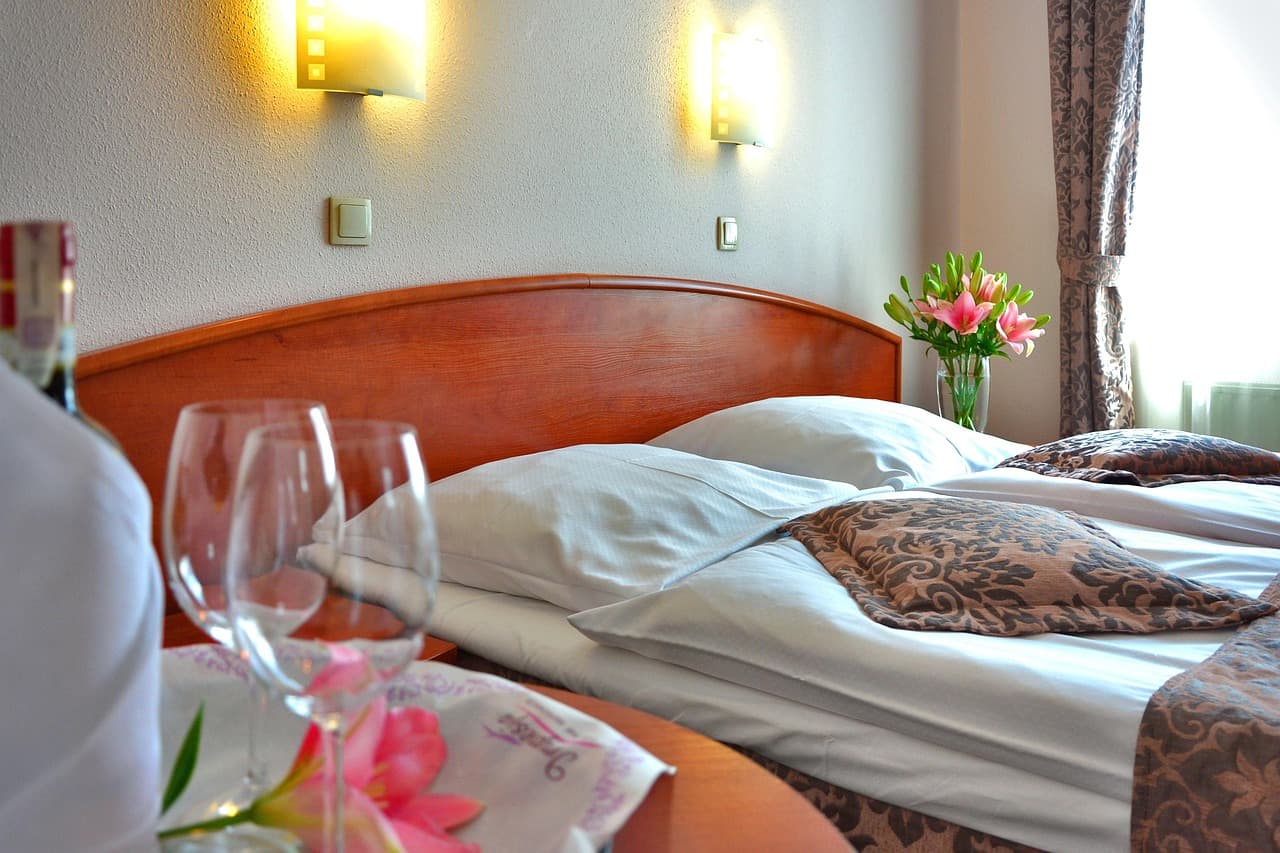 Hotelzimmer in warmer Beleuchtung, Bettwäsche und intime Lichtatmosphäre